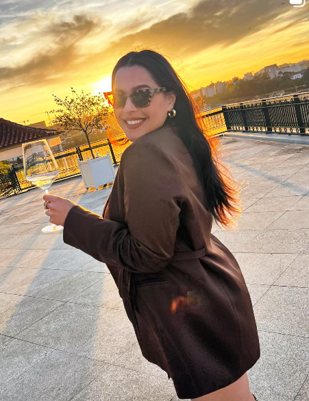 Gisele at golden hour with a glass of wine in Brazil